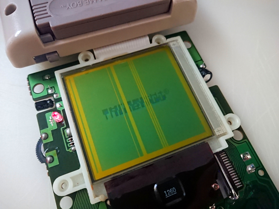 Rozebrana konsola Nintendo Game Boy z brakującymi liniami obrazu i zepsutym logo Nintendo na ekranie
